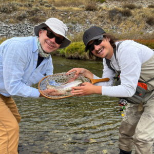 Guest and guide hold rainbow trout